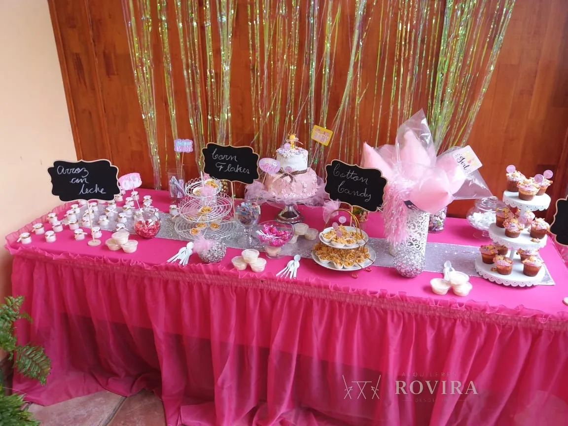 Mesa de dulces (candy table) en fucsia con faldón, backdrop de flecos dorados, cupcakes y pizarras con etiquetas