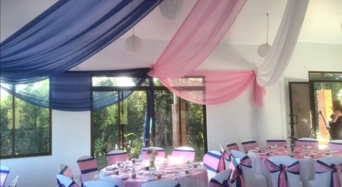 Techo de tela azul marino, rosa y blanco en salón moderno con ventanales