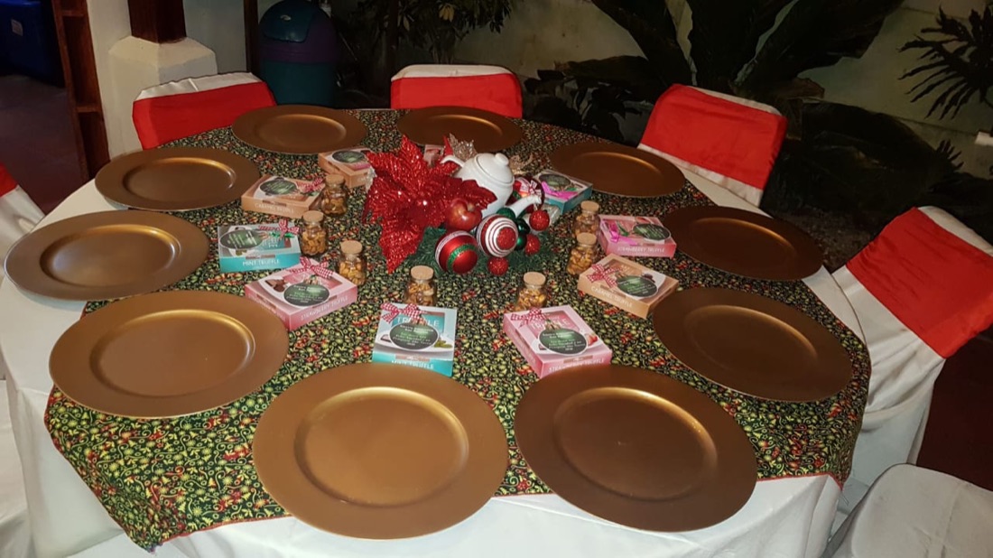 Mesa larga vestida en azul marino con platos base dorados, servilletas blancas y centros florales rosados