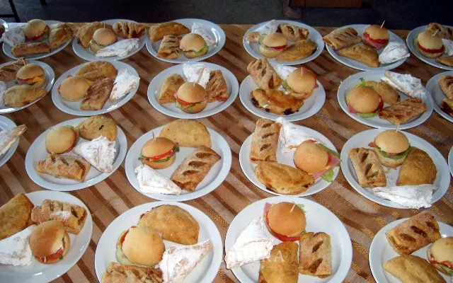 Bocadillos servidos en platos medianos en fila para los invitados, servicio de catering