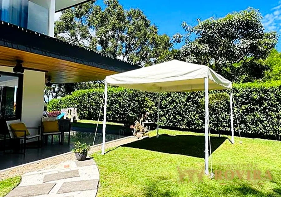 Carpa plegable blanca en jardín