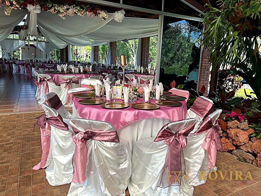 Centro de mesa de XV años con globo dorado en forma de número, flores gerbera y velas